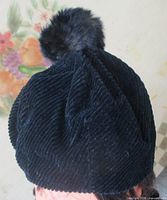 Rear view of navy corduroy tam with fur pom pom