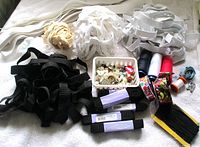overview of entire lot showing elastics, buttons, threads, tape measure, clips