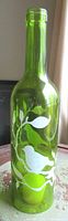 Full view of green cut wine bottle with painted birds