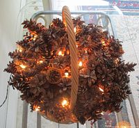 Top view of illuminated pine cone arrangement in wicker basket