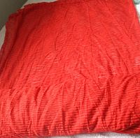 Folded length of burnt orange striped sheer fabric