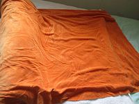 Folded burnt orange velour fabric on surface