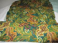 Folded green paisley fabric showing overall pattern