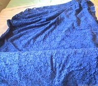 Full view of indigo blue lace fabric laid out