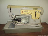 Left side view of Singer Stylist 457 sewing machine on base with foot pedal and cord
