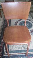 Front view of vintage faux wood chair showing seat, backrest and tubular legs