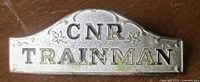 Front view of CNR Trainman badge showing raised lettering and design