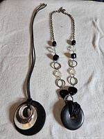 Both necklaces laid flat showing full length and pendants