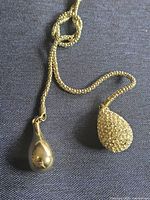 Coiled necklace laid flat, showing chain type and pendant attachment