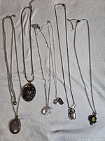 All six necklaces laid out to show length and pendants
