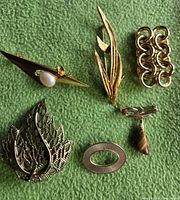 All six brooches arranged on green background