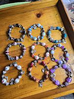 All nine bracelets laid out on wood tray