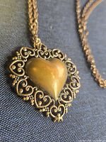 Close-up of copper-tone filigree heart pendant