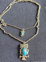 Entire necklace laid flat showing both owl pendants and chain