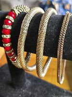 All four bracelets displayed on black bracelet stand