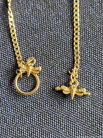 Close-up of the two dragonfly elements and ring-and-bar closure on chain