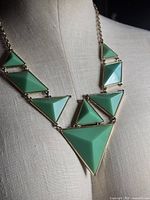 Front view of necklace on dress form highlighting green triangular panels