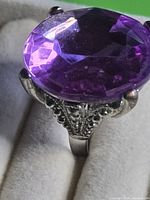 Side view of adjustable ring showing large faceted glass stone and filigree setting