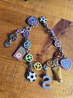 Full bracelet showing peace sign links and assorted dangling charms