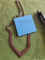 Full view of red rhinestone necklace on fabric background