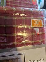 Close-up of fabric pattern, burgundy plaid, and 36" length sticker