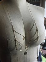 Full view of gold tone layered necklace on mannequin