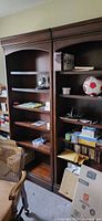 Two matching dark wood bookcases filled with assorted items