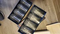 Two open boxes each holding six crystal tumblers