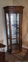 Full view of wood and glass corner curio cabinet