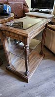 Front angled view of wood hall table with glass top and lower shelf