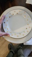 Small plate with gold star border resting on larger plate with gold rim
