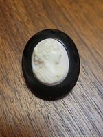Front view of cameo brooch showing white portrait on black border