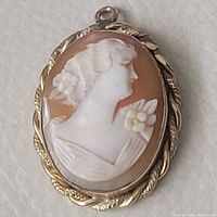 Front view of cameo pendant showing woman's profile and metal bezel