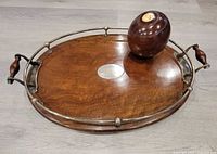 Top view of oval wooden tray with metal rail and rosewood ball