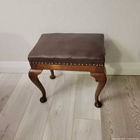 Front view of walnut stool with leather seat and cabriole legs