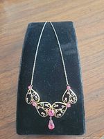 Full view of necklace on display stand showing overall design and chain