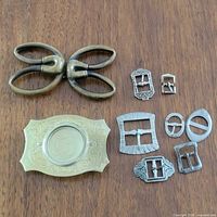 All eight belt buckles arranged on wooden surface