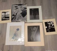 Six matted photographs laid out on floor