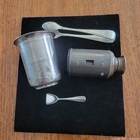 Overview of cup, two spoons and scope on black background