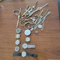 Entire lot laid out showing all watches, parts and bracelets on table