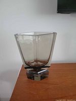 Front view of smoky gray faceted glass vase showing pedestal base and geometric form