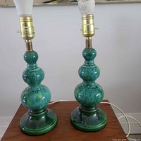 Pair of green glazed ceramic table lamps on table