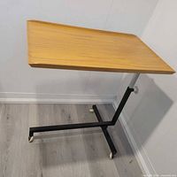 Full view of trolley showing wood veneer top, metal frame and casters