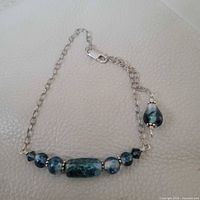 Full view of bracelet showing chain, beads, clasp, and dangle charm