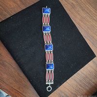 Full view of bracelet showing alternating blue and red stone panels and clasp