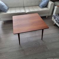 square teak coffee table displayed in living room setting