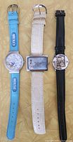 Front view of three Disney watches showing straps and dials
