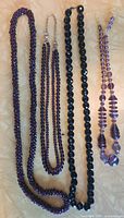 Full view of four necklaces laid out side by side