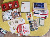 Assortment spread on table showing cards, postcards, writing paper, seals