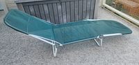 Side view showing full length lounger with white frame and green mesh